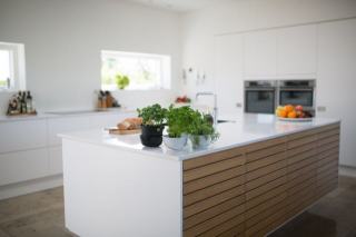 Îlot central de cuisine avec plan de travail et tabourets, vu de trois quarts