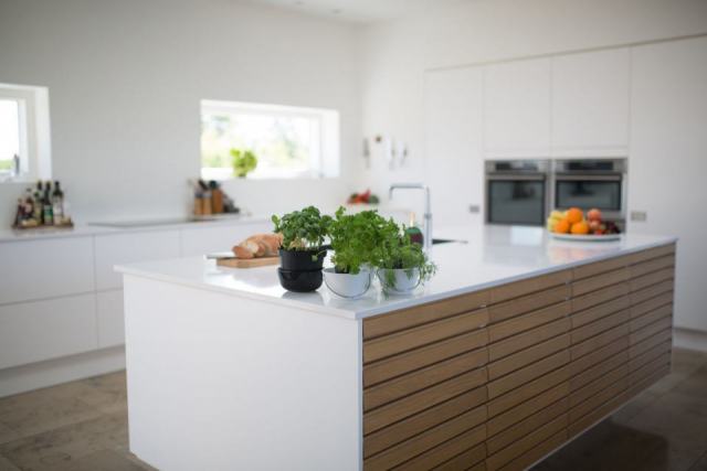Îlot central de cuisine avec plan de travail et tabourets, vu de trois quarts